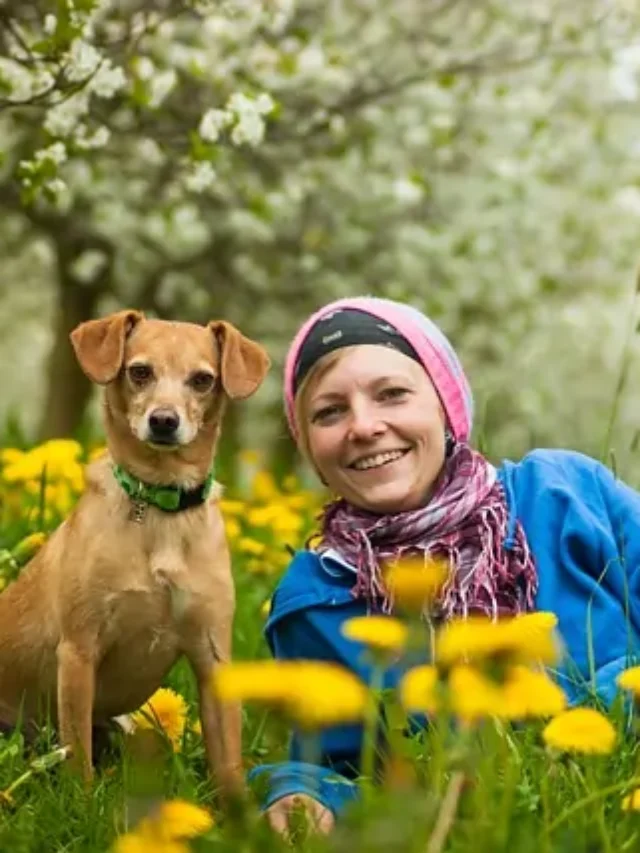 A dog and lady sitting together and laughing.